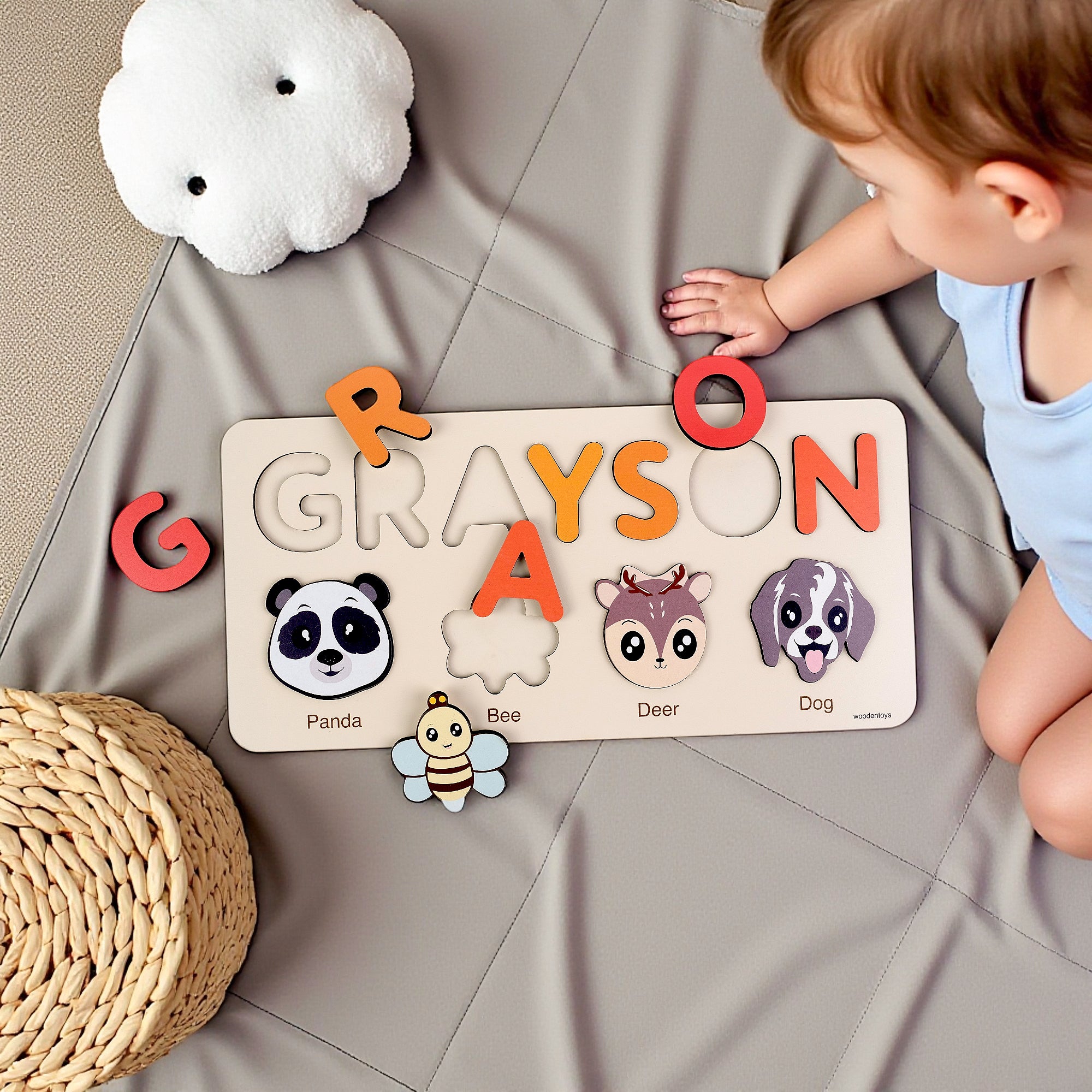 Child playing with a personalized name puzzle on a soft surface